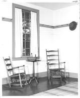 SA0527.2 - Photo of an exhibit at Dunham Tavern Museum, Cleveland, Ohio, showing the museum's Shaker room: chair and rocking chair, footstool, table, basket, candle, and hat on peg., Winterthur Shaker Photograph and Post Card Collection 1851 to 1921c